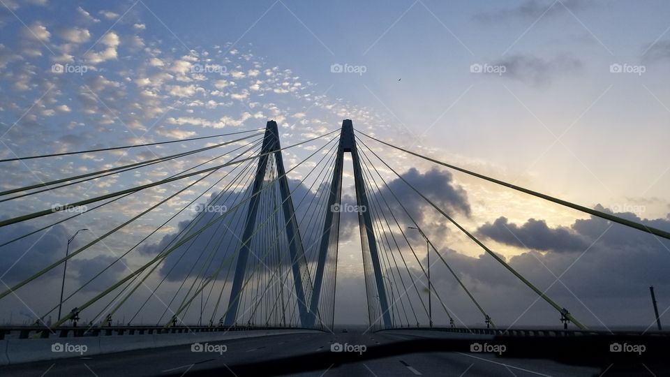 The Fred Hartman Bridge in front of a sunrising sky.