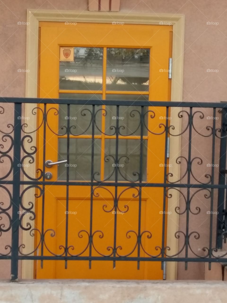 Yellow door in the city with railings