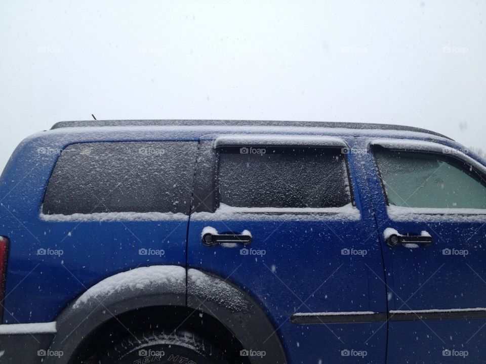 snow on blue SUV