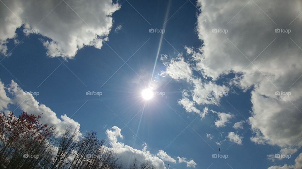 sunshine in blue cloudy sky