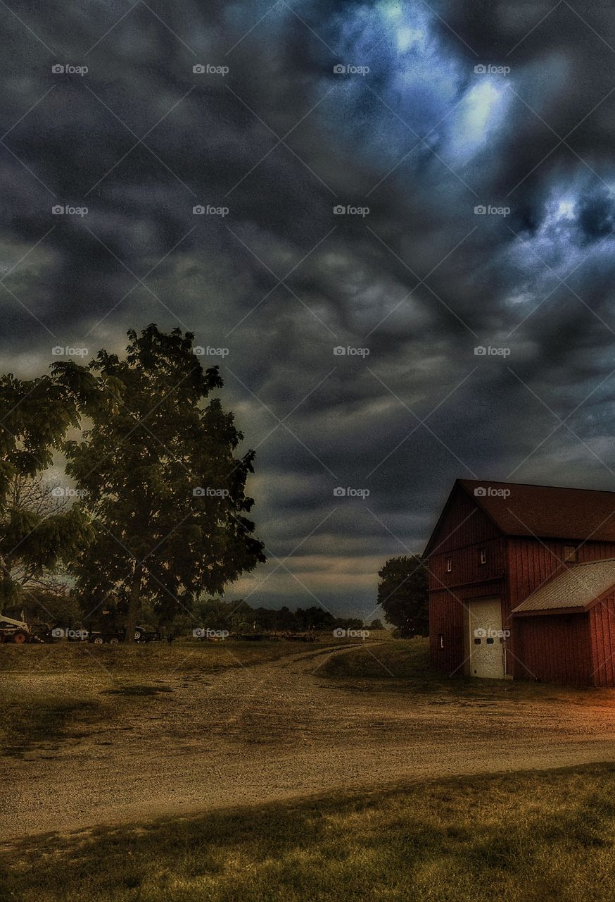 Barn under stormy skies . Thunderclouds rolling over a farm. 
