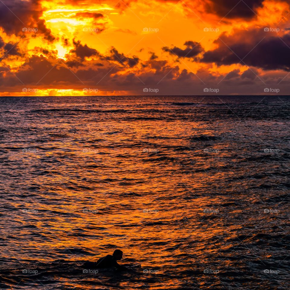 Paddling out under a tropical sunset 