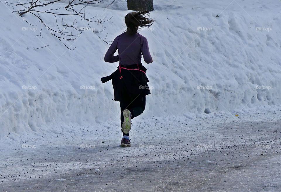 Running in a snow covered road. Winter presents its own special challenges. When the land is covered with a coating of snow and ice outlines branches, the outdoors are transformed into a magical place