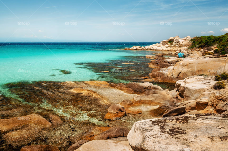 Wild rocky beach with turquoise transparent water and large stones I Vourvourou, Halkidiki, Greece