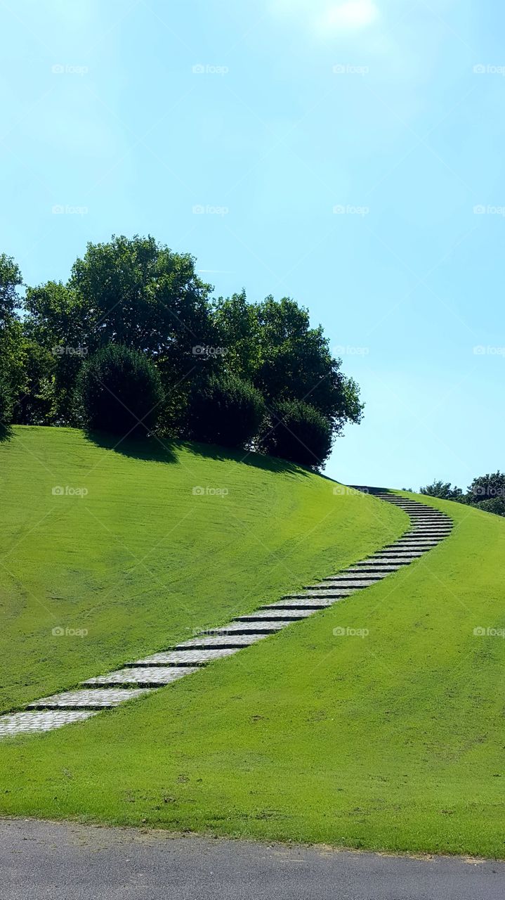 Stairs on green grass over the hill