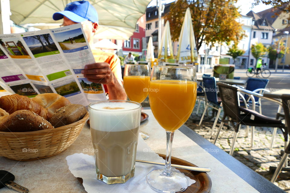 a man reading a tour prospect while having a breakfast