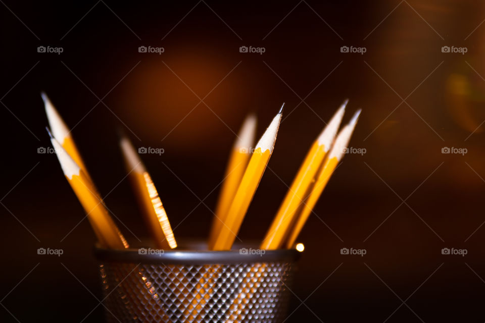 focused on pencils in cup with light flare
