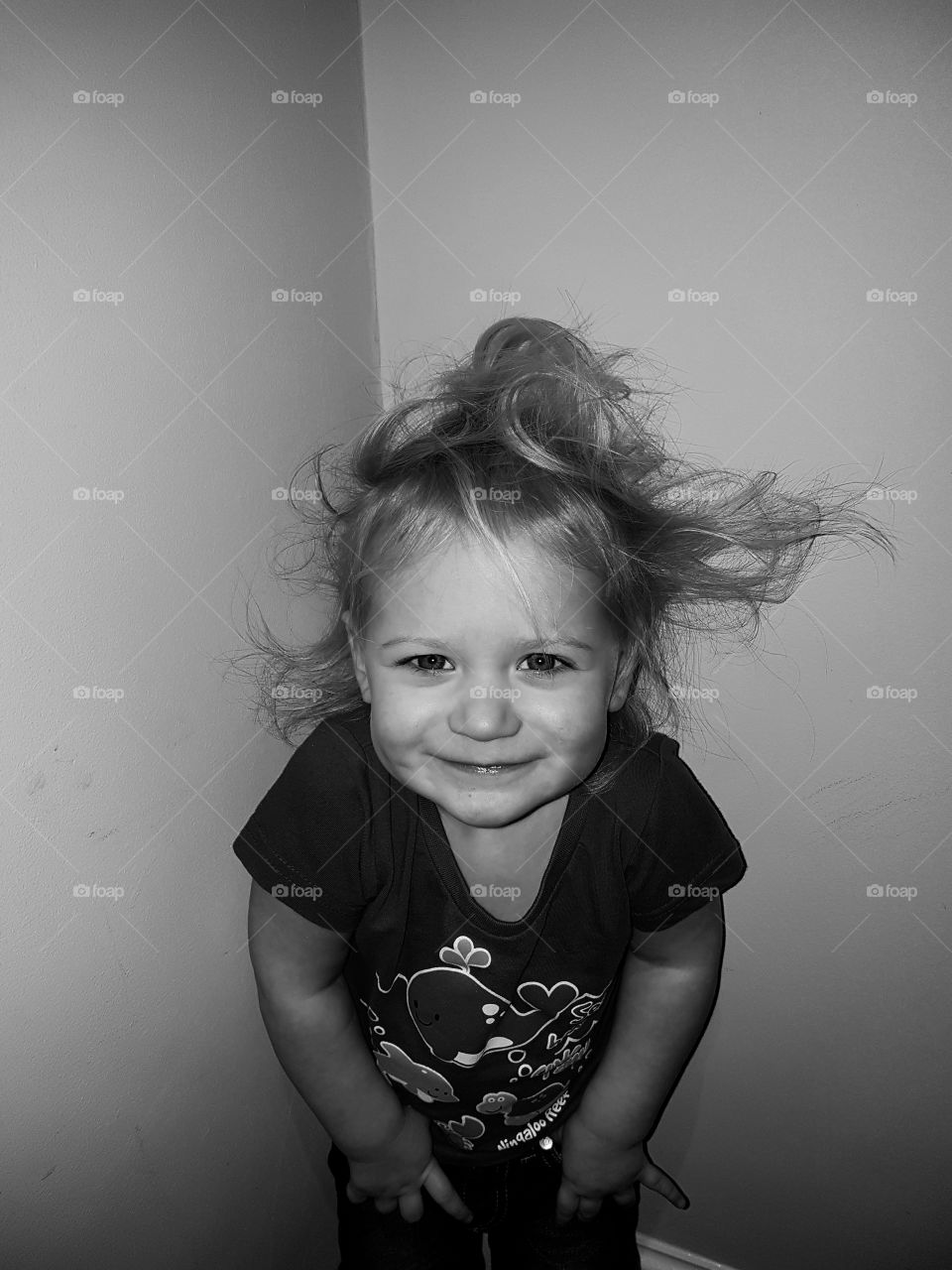 Cheeky little girl with messy hair in black and white