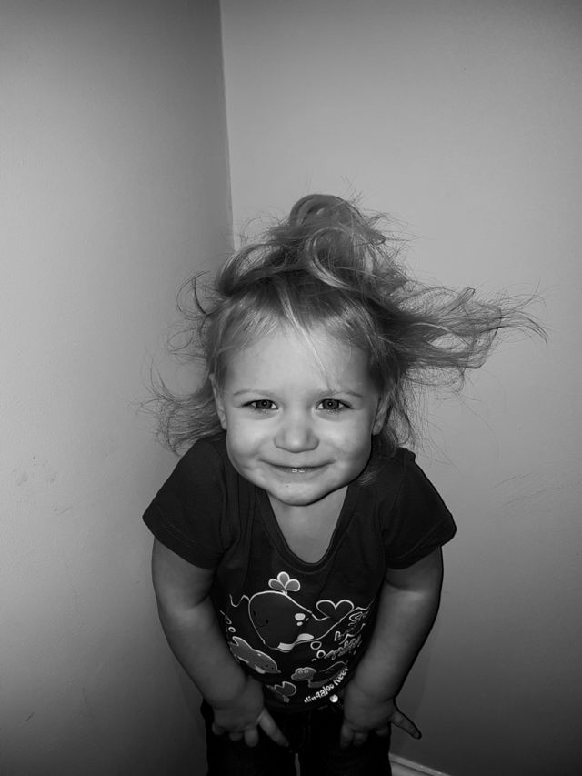 Cheeky little girl with messy hair in black and white