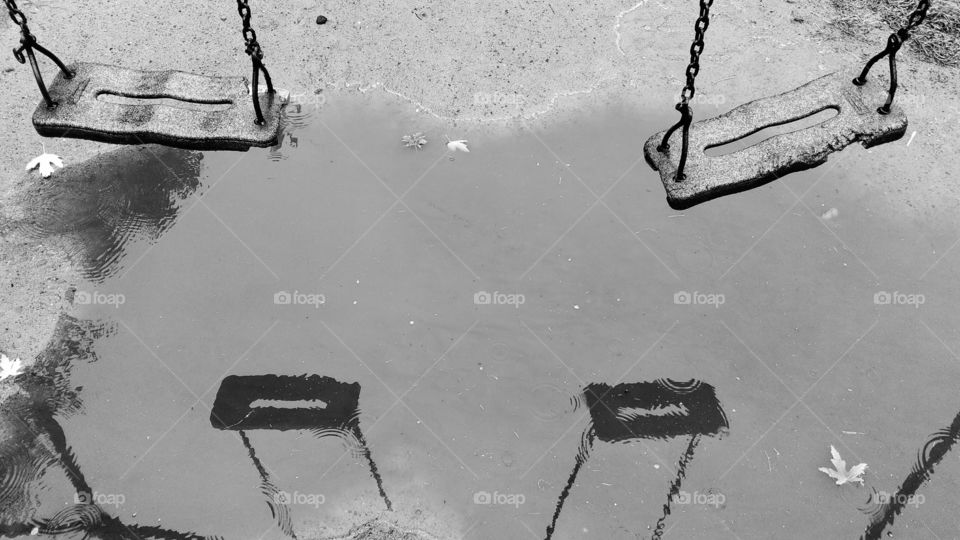 Reflection of children's swing in a puddle