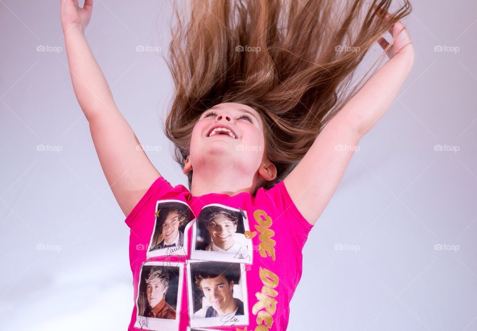 The long hair of a young girl stands up as she jumps for Joy.