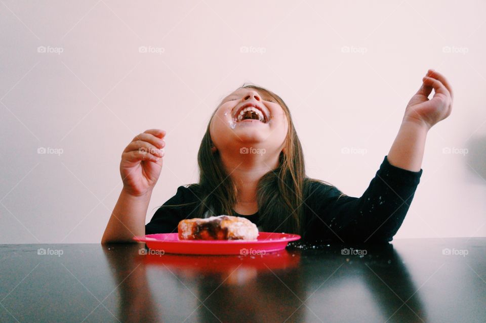 A little girl eating food and laughing
