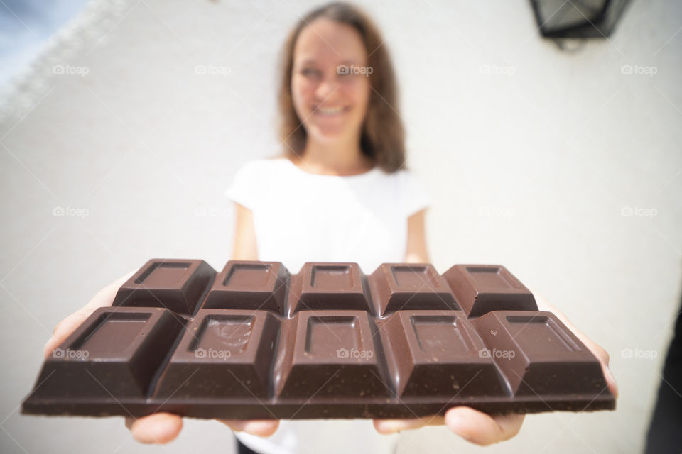 The girl is holding a big chocolate