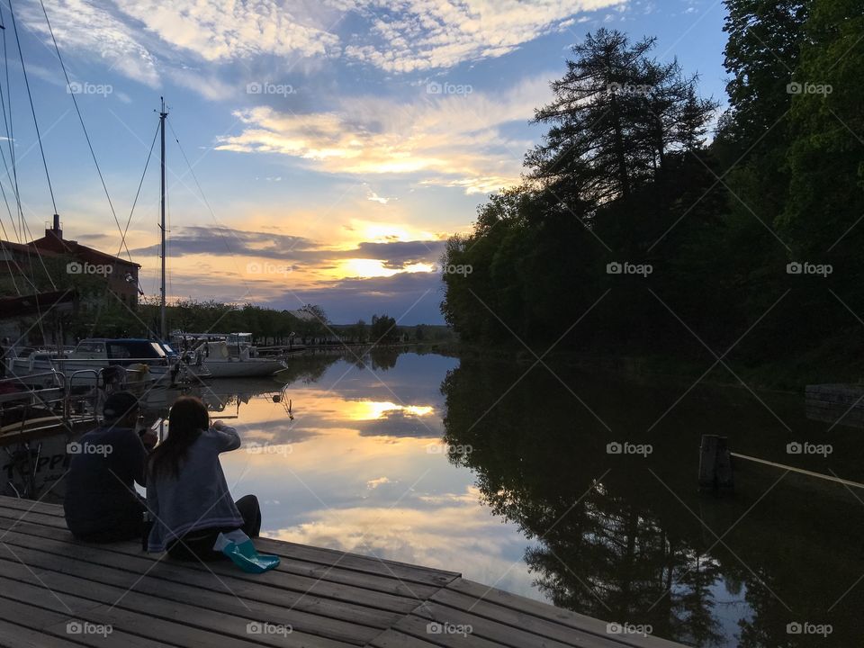 Two people sitting on dock