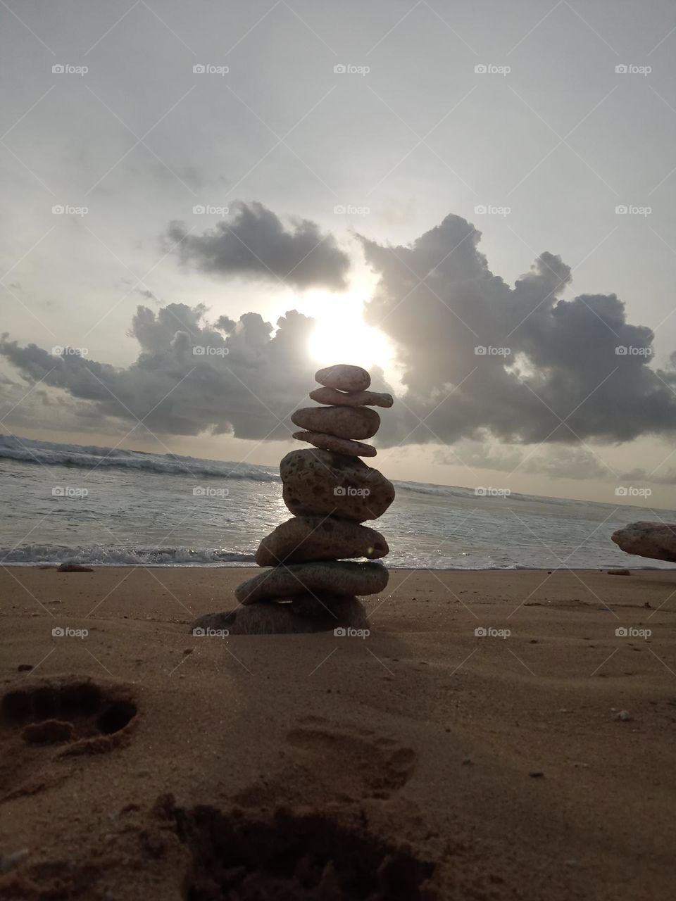 stack of pebbles at the beach while waiting for sunset