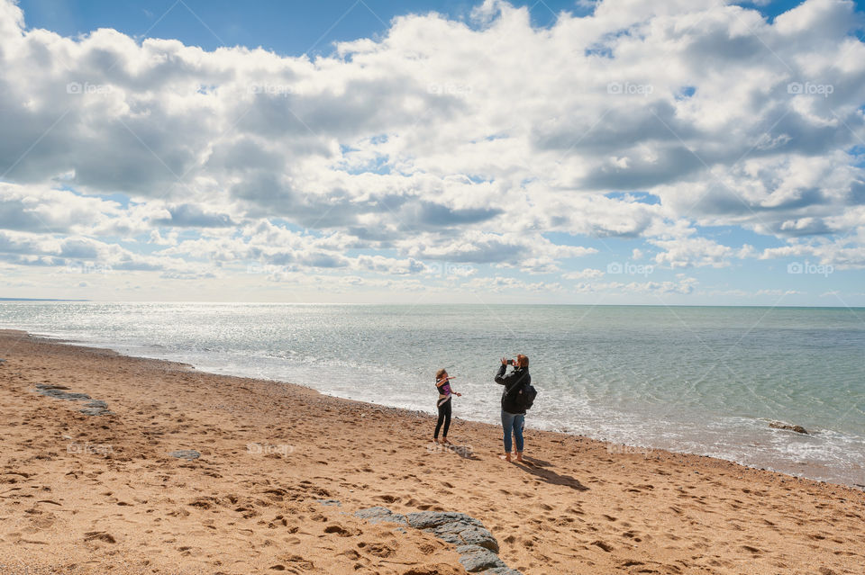 Mother and daughter enjoy quality family time at remote coastline.