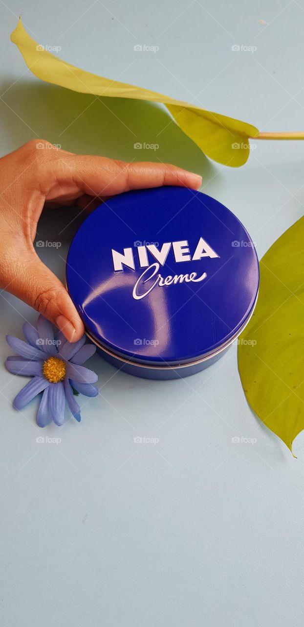 circle shapped nivea cream container in hand