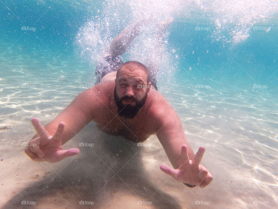 bearded diver underwater. bearded diver underwater with hands spread out