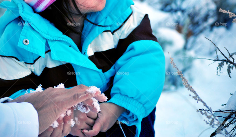 Kid, toddler, playing with snow ball on hand, mom