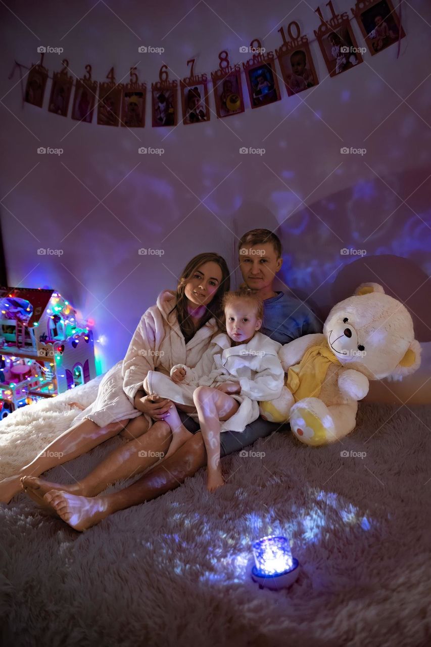 happy family at home on the sofa watching the projector