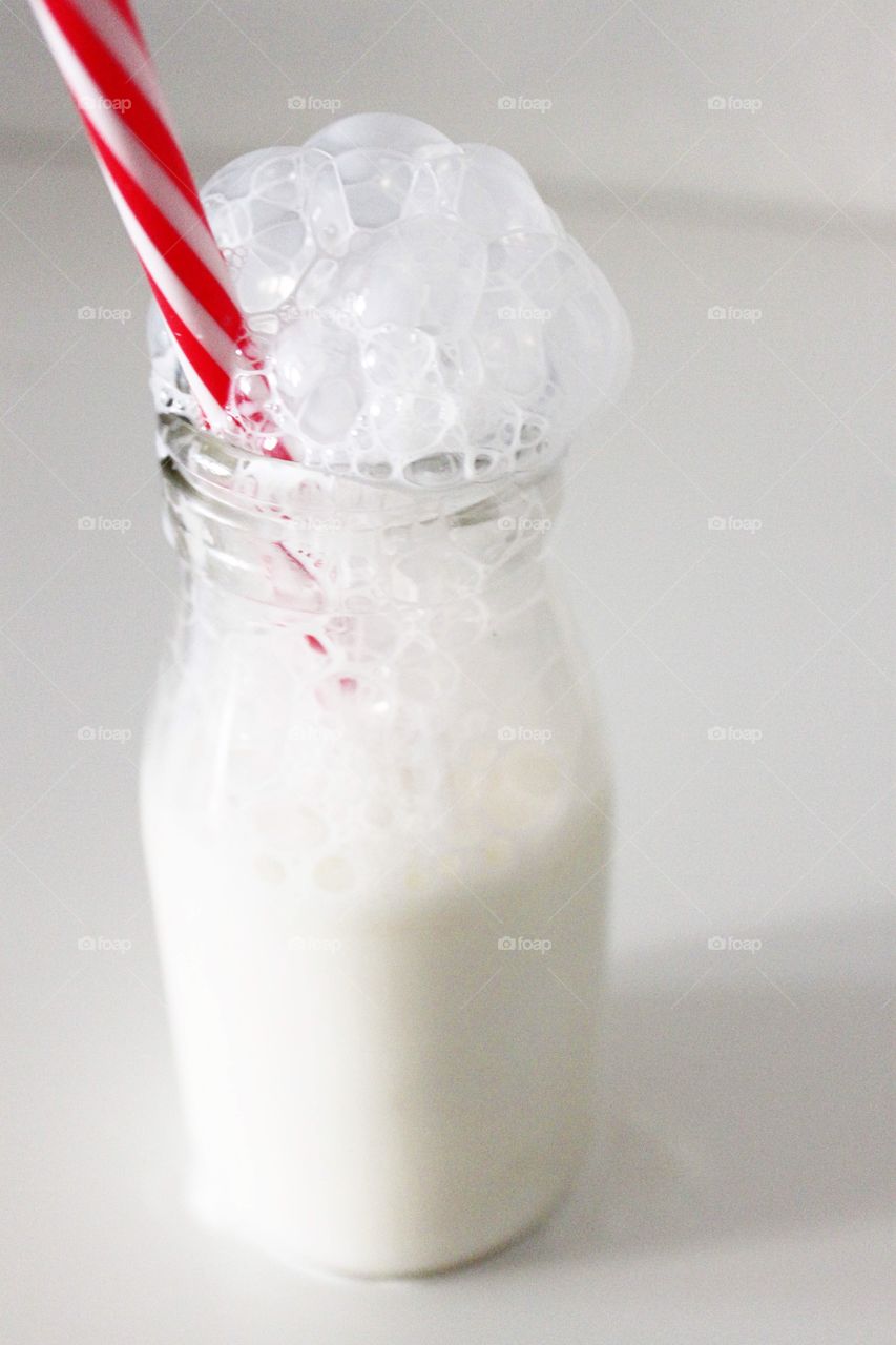 Milk in bottle with striped straw