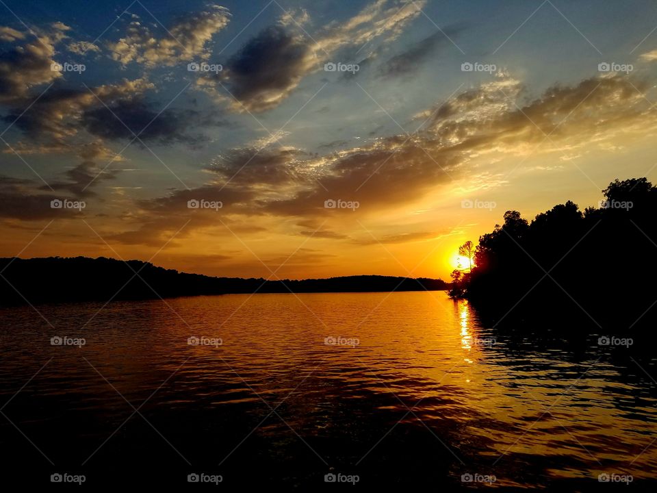 sun setting over lake