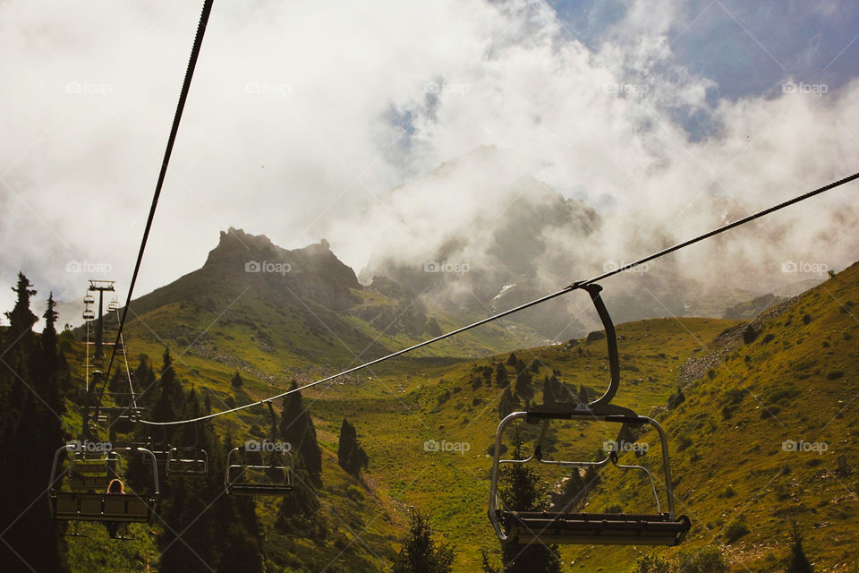 Ski gondola road going through the clouds in the mountains of Kazakhstan