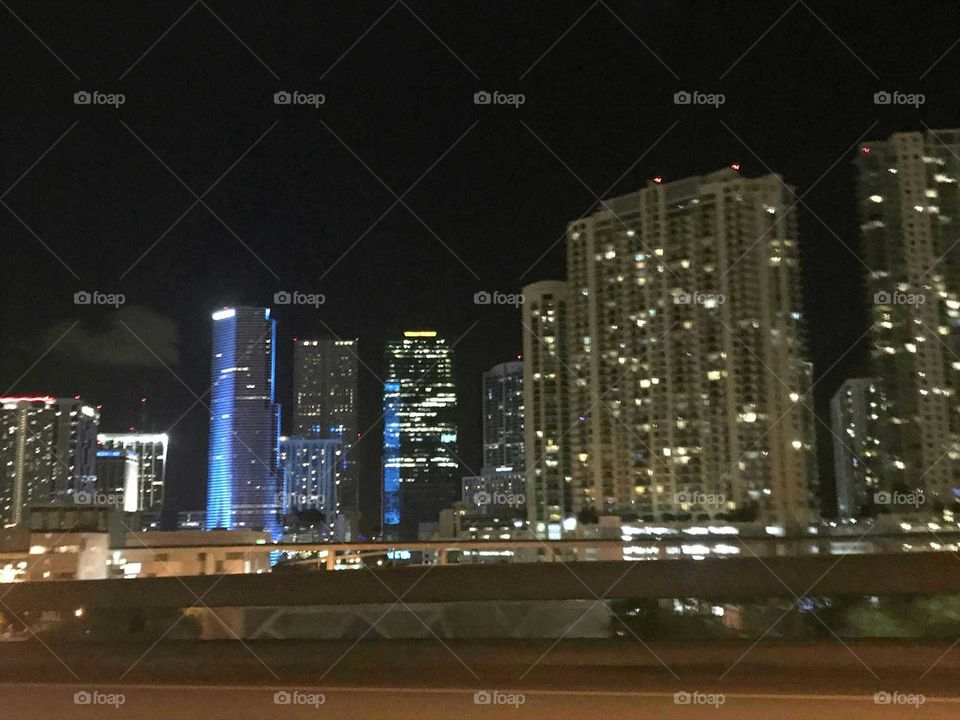 Downtown Miami at night. The skyline lights up the night as my girlfriend captured this picture from a moving vehicle passing over a bridge. The colorful buildings in the center look pretty cool at night with the different lighting. This was done well by my talented aspiring photographer girlfriend from Lima, Peru.