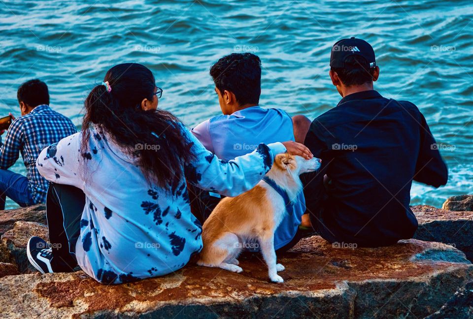 People relaxing in the sea shore with pet 