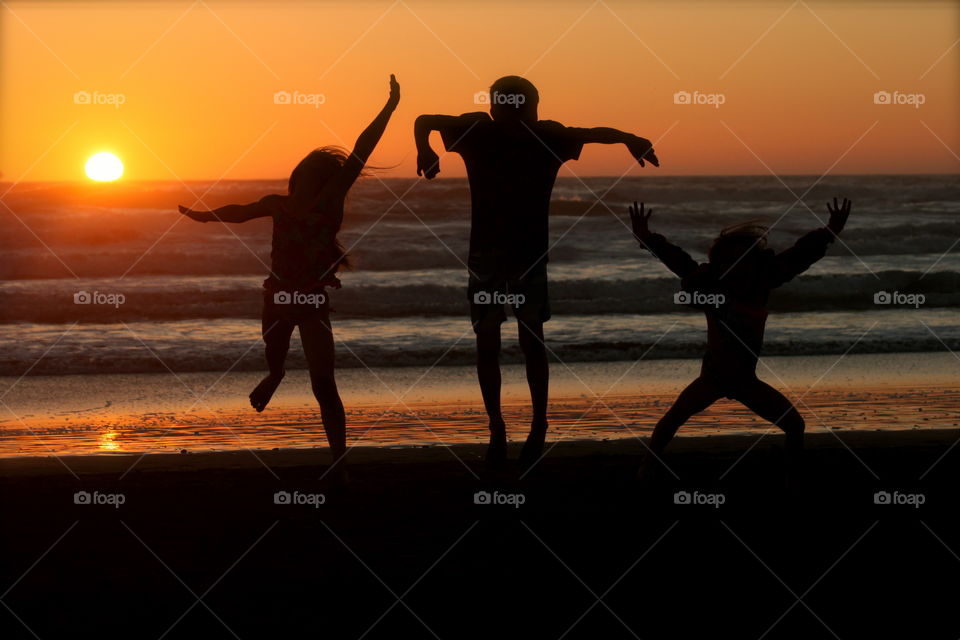 Jump for joy, sunset over the pacific
