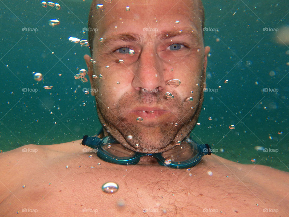 man underwater. man making bubbles underwater