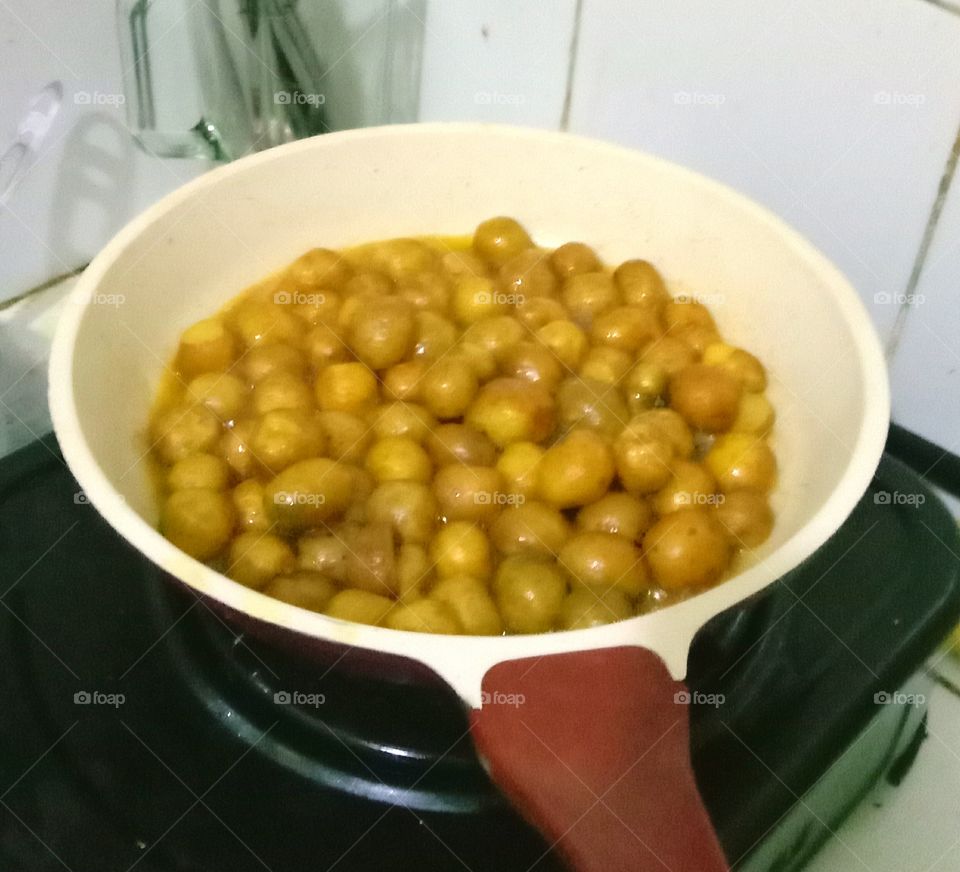 Baby potatoes in a pan fried with butter using small fire. Evening meal  is coming soon.