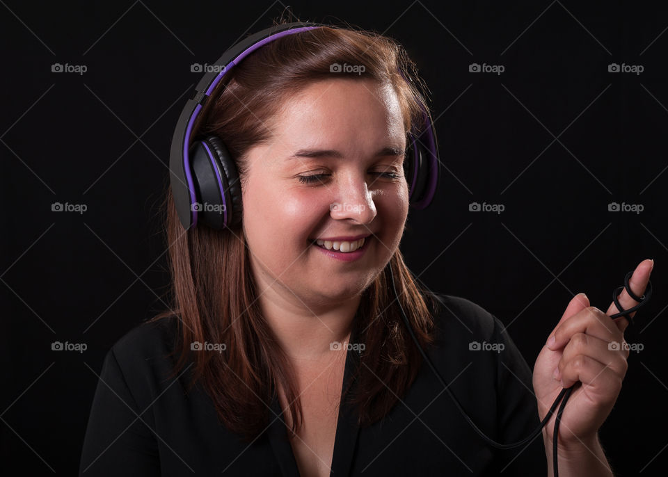 Happy young women listening to music on headset.