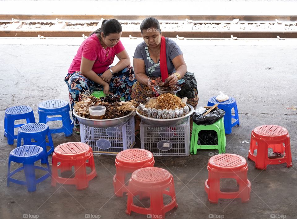 Rangoon/Myanmar-April 14 2019:Woman’re sitting to sell goods to visitors at central platform in Myanmar New Year 