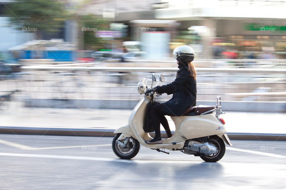 Woman on Vespa scooter.
