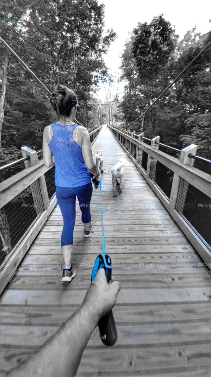 b&w color splash woman walks dog over bridge