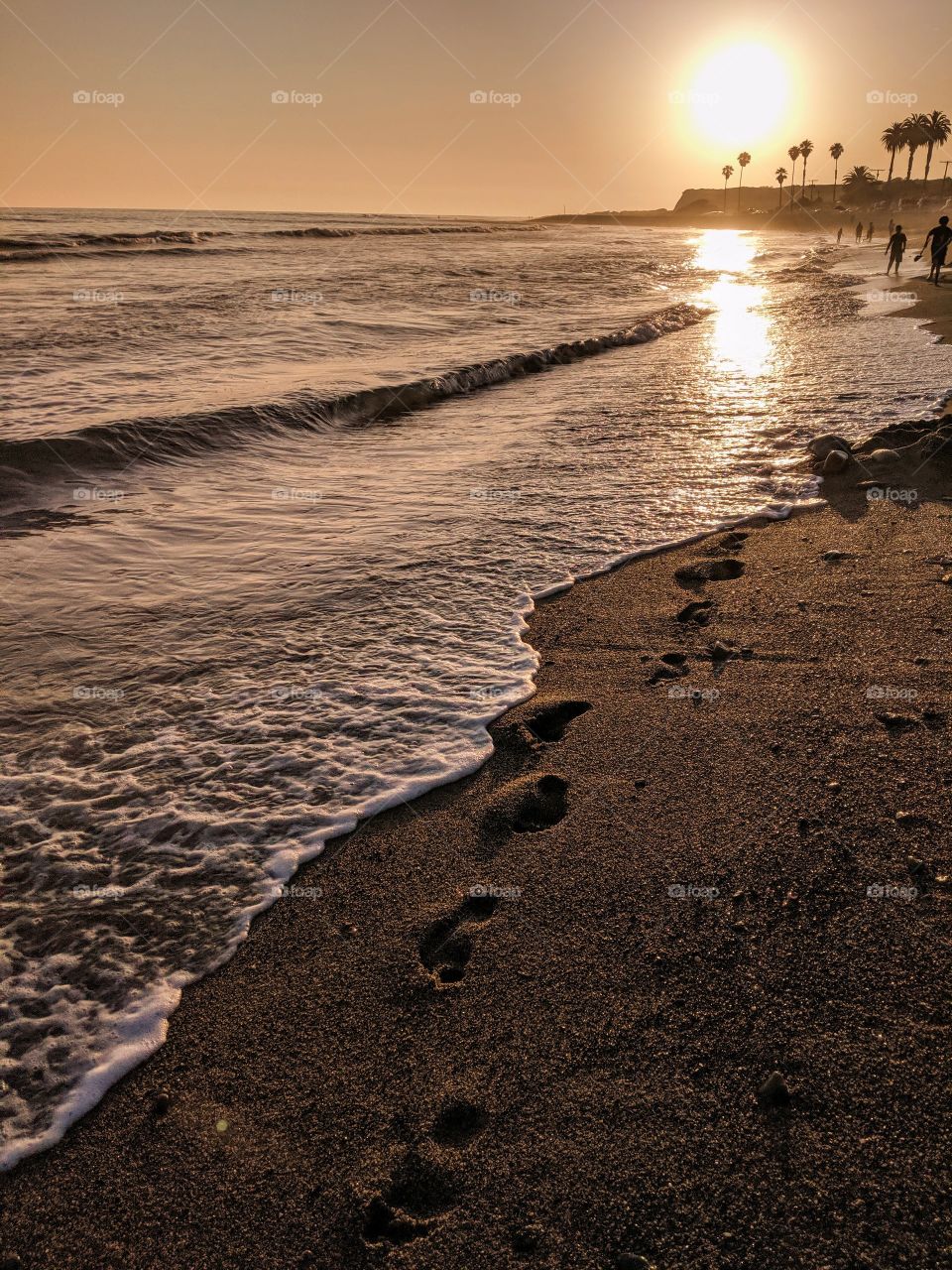 Sunset at San Onofre Beach California, Dramatic lighting with footprints in the shoreline.