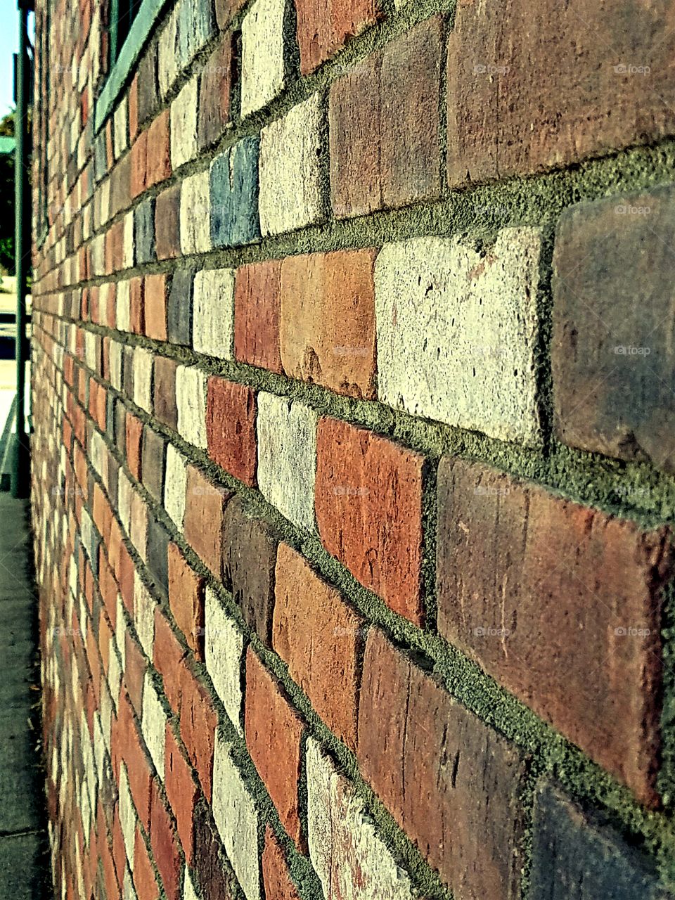 Looking down the side of an old brick wall.