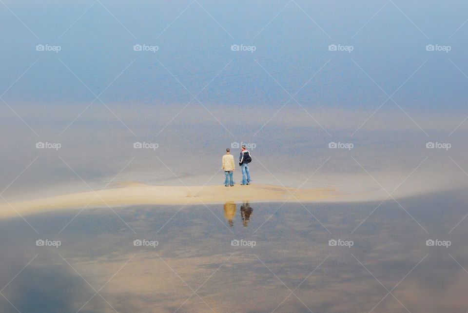 Two people syanding in the center of sea