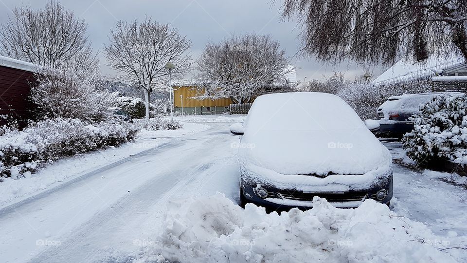 Winter, car  covered with snow parked in a snowy road  - vinter, bil täckt med snö parkerad på snöig gata 