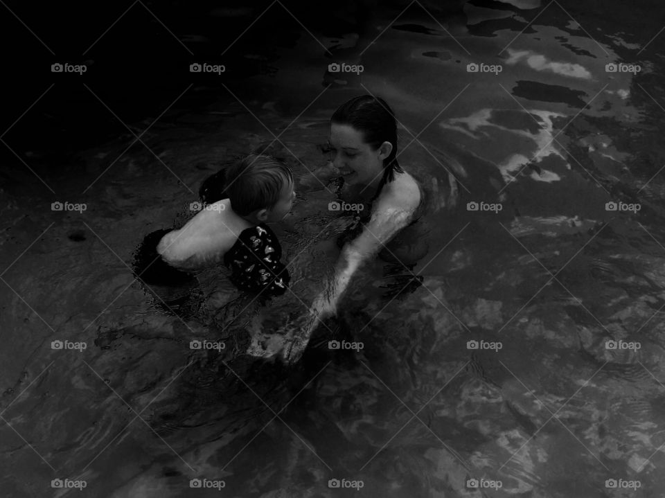 Mother and son swimming in water