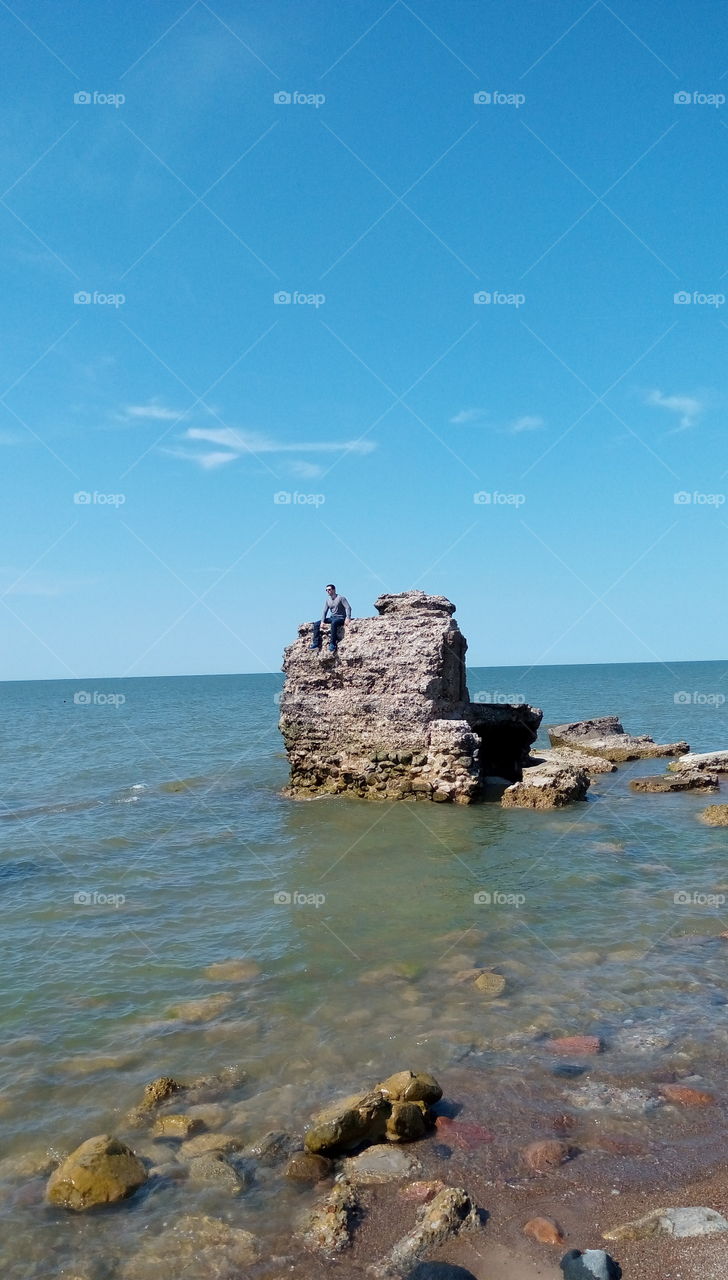 Man sitting on a ruins i the sea