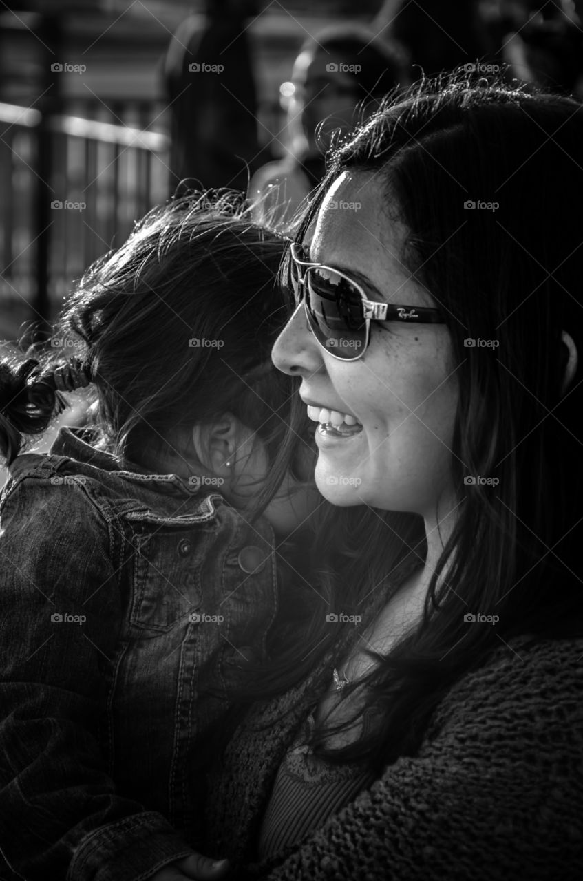 Woman and her Child . Smiling woman with Sun glasses with her daugther in her arms 