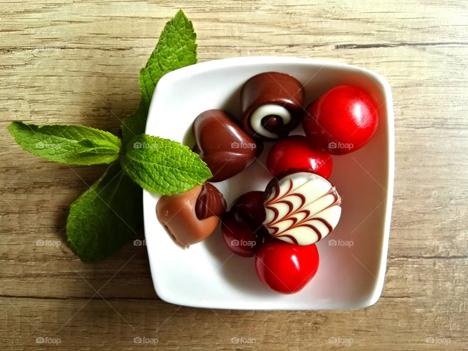 Chocolate mint and cherries on wooden table
