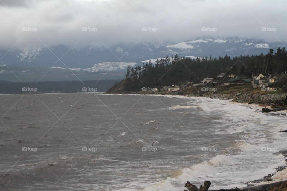 Some sunrise shots of the ocean on a windy Pacific Northwest morning. The mountains were misty and the sun was attempting to shine through but I could see clouds growing and darkening. Whitecaps were visible and the sea was dark blue.