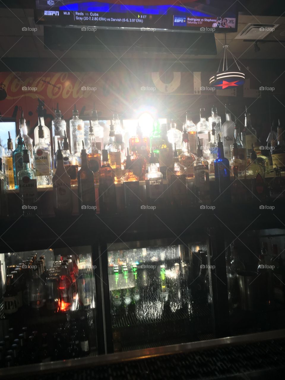 Sunshine shining through liquor bottles at the bar