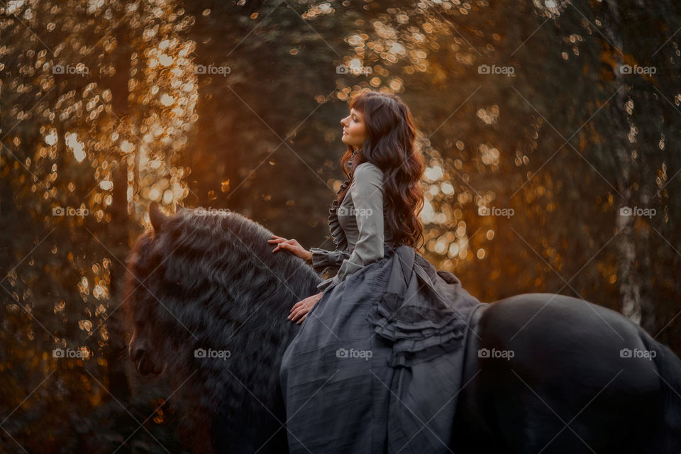 Beautiful young woman on black stallion 