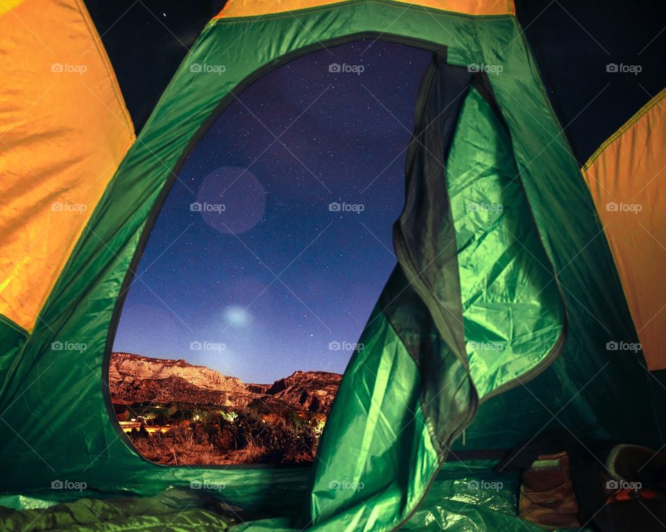 Camping in a tent under the stars and mountains in the colorful Utah desert