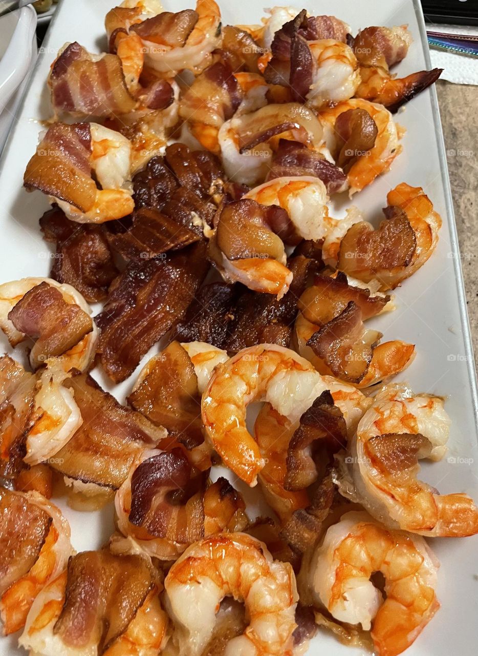 A plate of bacon wrapped shrimp. 