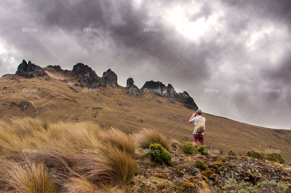 Man taking a picture in a mountainous region 